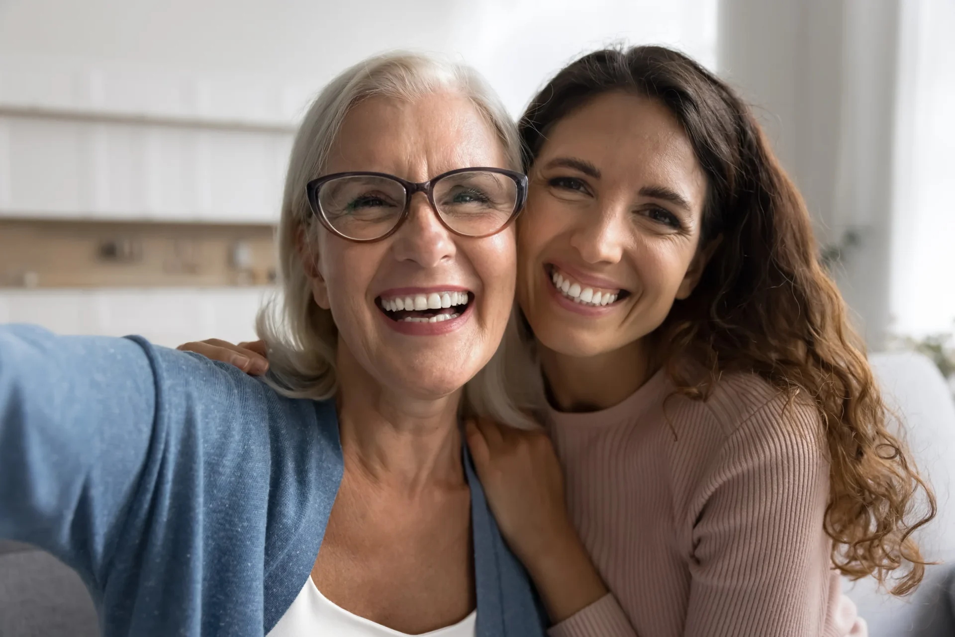Two smiling women posing together at home