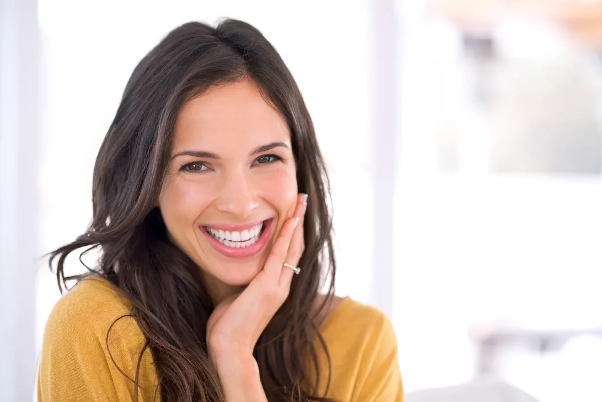 Smiling woman resting her hand against her cheek